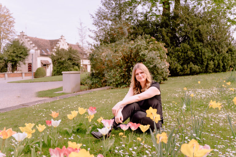 Ramona sitzt auf einer Blumenwiese